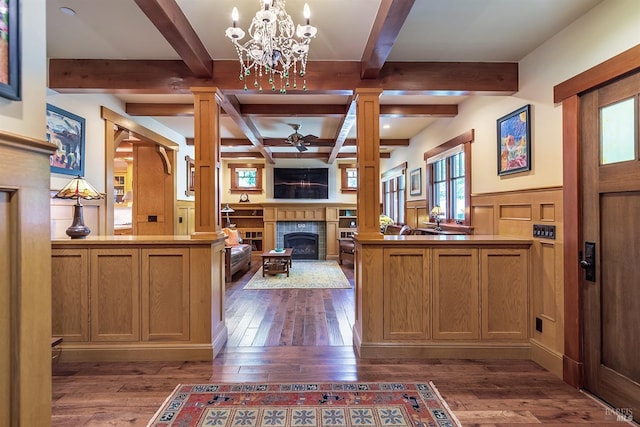 interior space featuring kitchen peninsula, dark hardwood / wood-style flooring, and a tiled fireplace