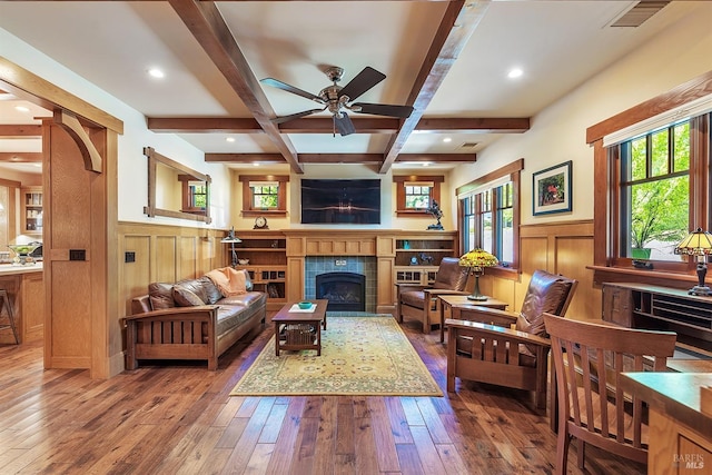 living room featuring coffered ceiling, ceiling fan, a tile fireplace, beam ceiling, and wood-type flooring