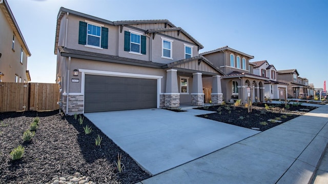 craftsman inspired home featuring driveway, stone siding, fence, board and batten siding, and a garage