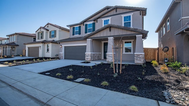 craftsman inspired home with stone siding, fence, board and batten siding, concrete driveway, and a garage