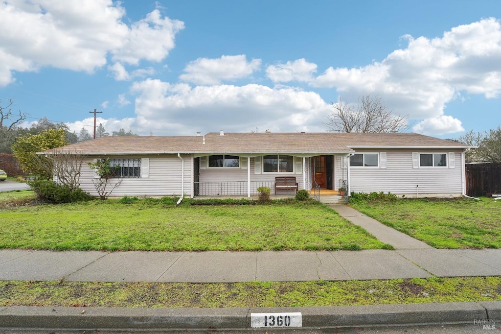 single story home featuring a porch and a front lawn