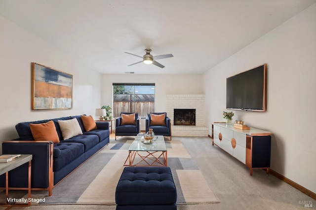 living room with ceiling fan, light colored carpet, and a brick fireplace