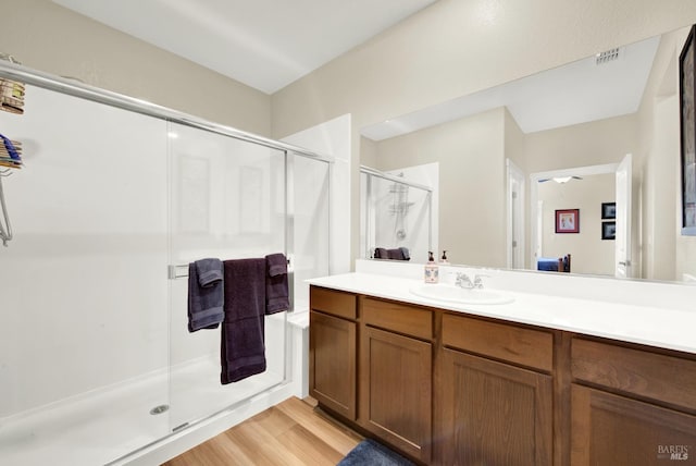 bathroom featuring wood-type flooring, vanity, and an enclosed shower