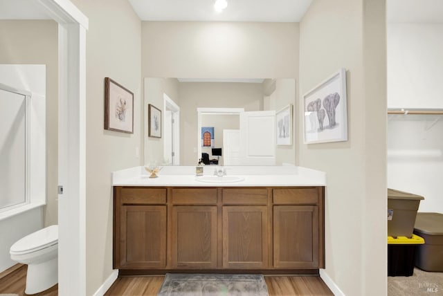 bathroom featuring vanity, hardwood / wood-style flooring, toilet, and an enclosed shower