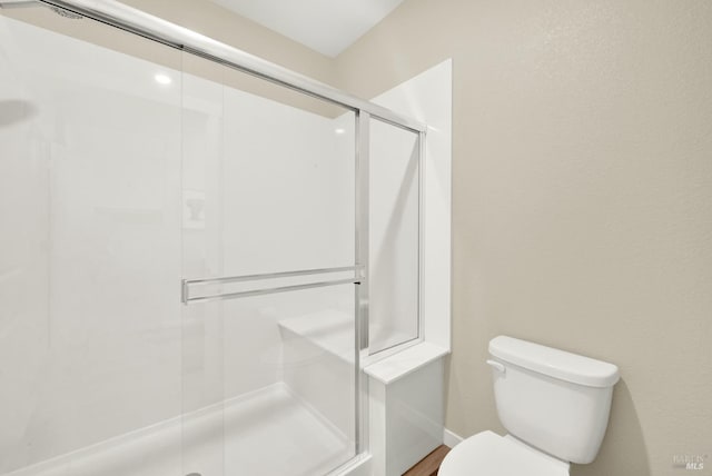 bathroom with an enclosed shower and toilet