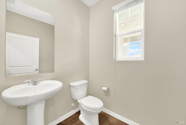 bathroom with hardwood / wood-style floors, toilet, and sink