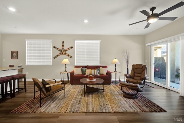 living area featuring ceiling fan and dark wood-type flooring