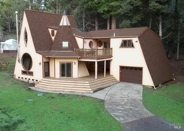 view of front facade featuring a garage, a balcony, and a front lawn