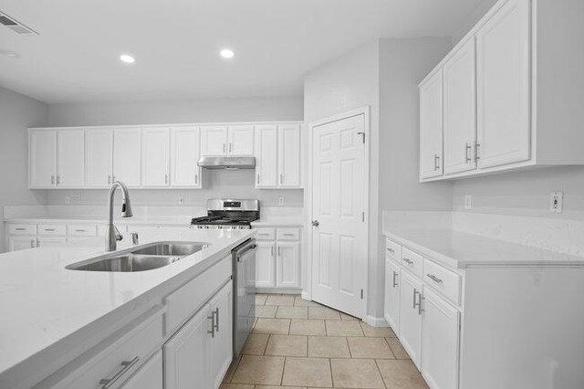 kitchen featuring light tile patterned flooring, appliances with stainless steel finishes, sink, and white cabinets