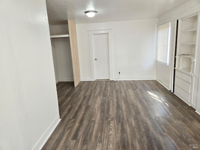 unfurnished bedroom with a textured ceiling and dark wood-type flooring