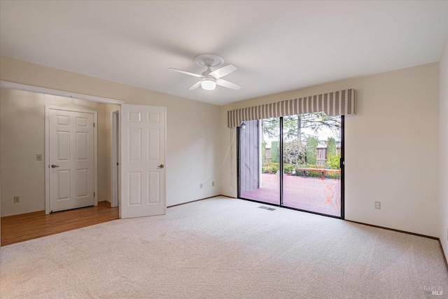 carpeted spare room featuring ceiling fan