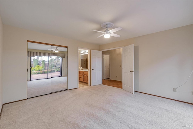 unfurnished bedroom with ensuite bathroom, light colored carpet, ceiling fan, sink, and a closet