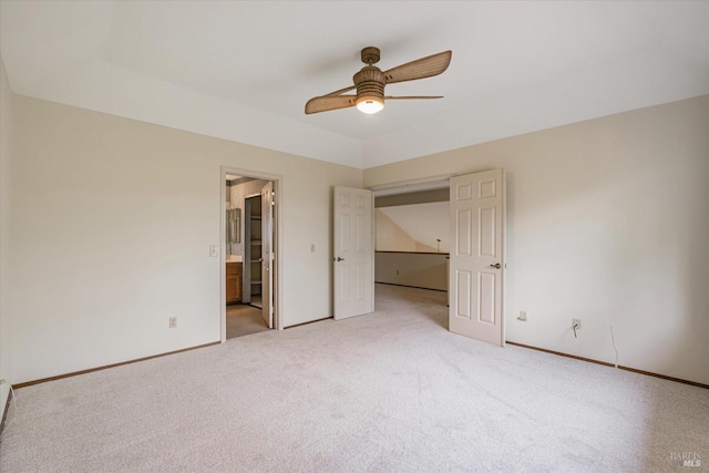 unfurnished bedroom featuring connected bathroom, light colored carpet, and ceiling fan