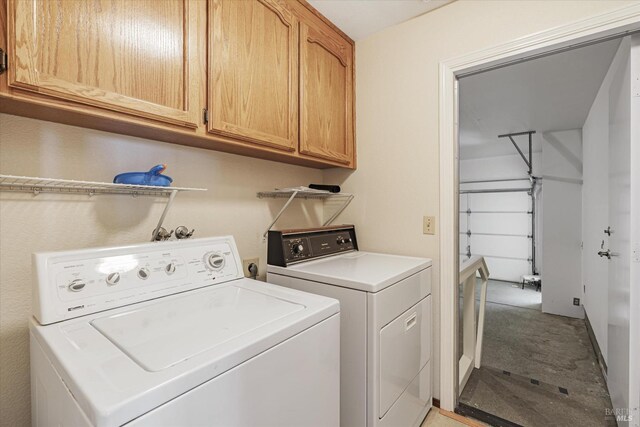 laundry area with washer and clothes dryer and cabinets