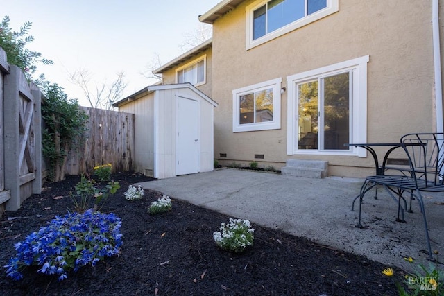 back of property with a storage shed and a patio area