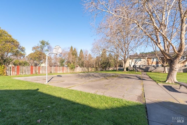 view of sport court with a lawn