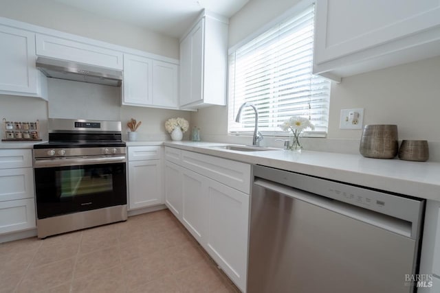 kitchen featuring light tile patterned floors, stainless steel appliances, sink, and white cabinets