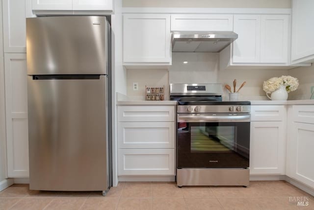 kitchen with white cabinetry, appliances with stainless steel finishes, range hood, and light tile patterned flooring