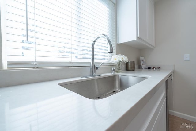 interior space featuring white cabinetry and sink