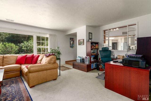 home office with light colored carpet and a notable chandelier