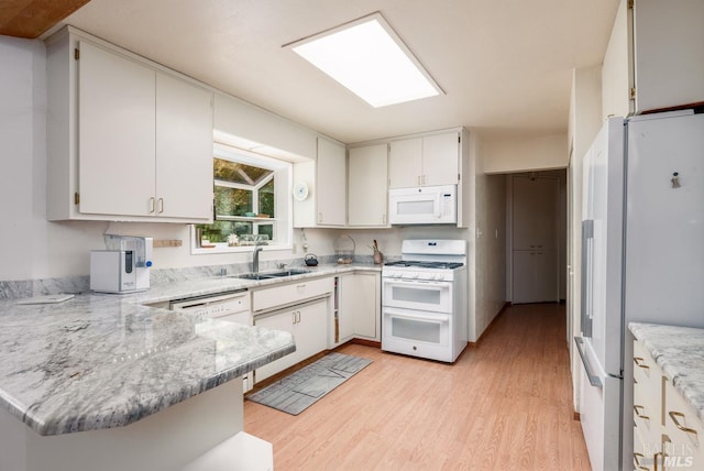 kitchen featuring white cabinetry, sink, kitchen peninsula, light hardwood / wood-style floors, and white appliances