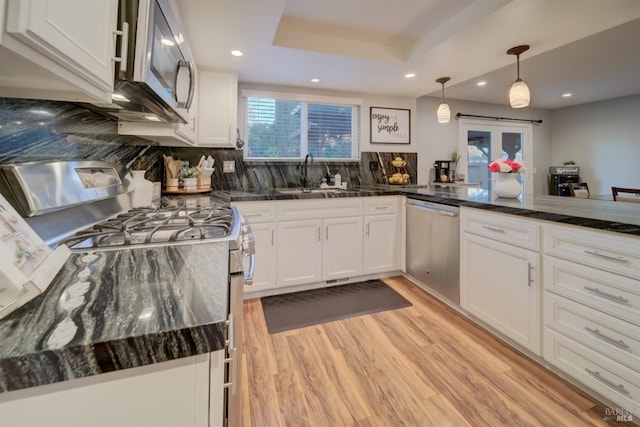 kitchen with decorative light fixtures, white cabinetry, sink, and appliances with stainless steel finishes