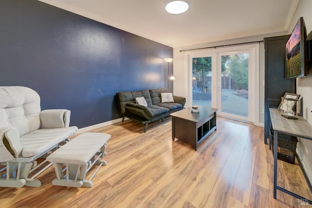 living room with light hardwood / wood-style floors and crown molding