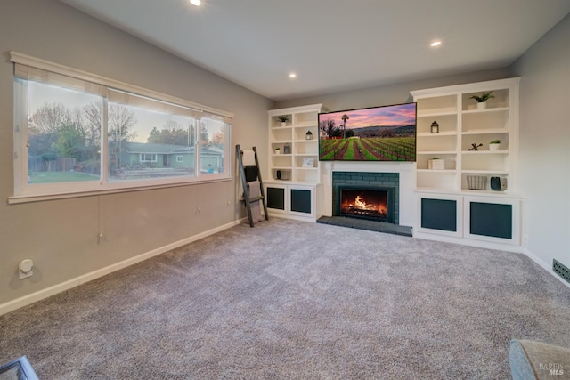 unfurnished living room featuring carpet floors and a brick fireplace