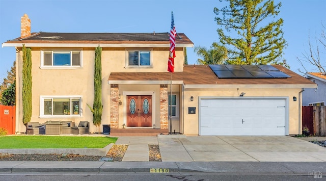 view of front of home featuring solar panels and a garage