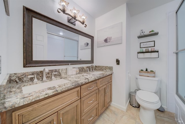 full bathroom with vanity, bath / shower combo with glass door, and toilet