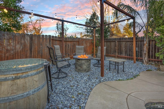 patio terrace at dusk featuring an outdoor fire pit