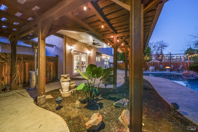 patio terrace at dusk with french doors, a fenced in pool, and ceiling fan