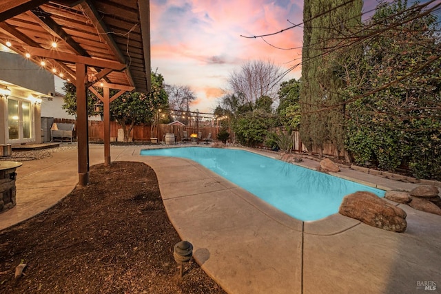 pool at dusk featuring a patio