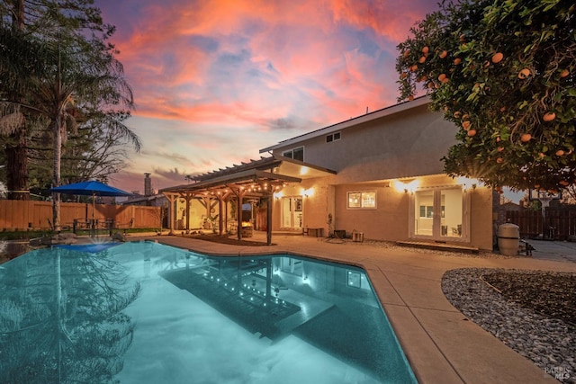 pool at dusk featuring a patio area