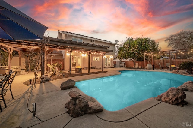 pool at dusk featuring a patio area