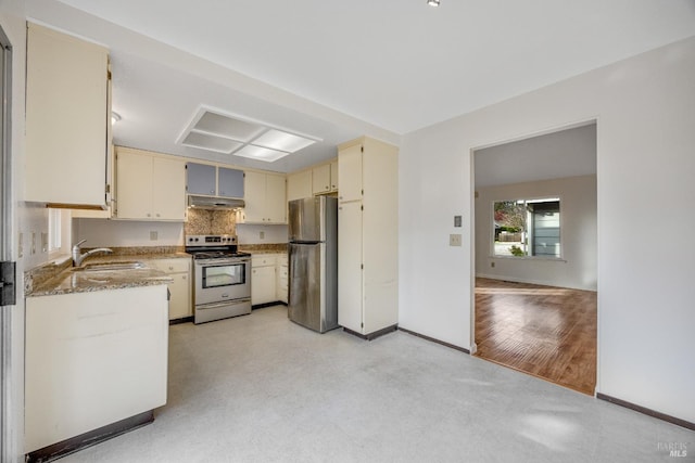 kitchen featuring sink, light stone counters, backsplash, cream cabinets, and appliances with stainless steel finishes