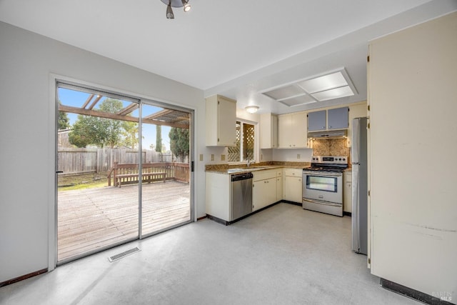 kitchen with cream cabinetry, decorative backsplash, sink, and stainless steel appliances