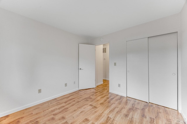 unfurnished bedroom featuring light wood-type flooring and a closet