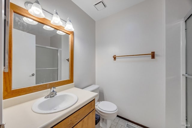 bathroom with vanity, a shower with shower door, and toilet