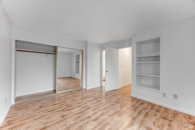 unfurnished bedroom featuring light wood-type flooring and a closet