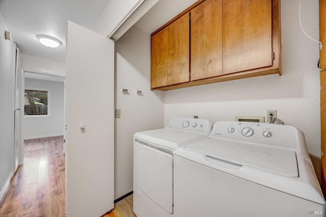 laundry area featuring light hardwood / wood-style floors, cabinets, and independent washer and dryer