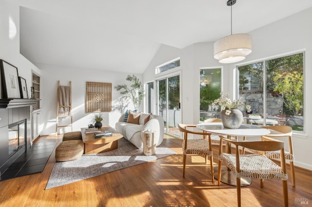 sunroom with plenty of natural light, lofted ceiling, and a tile fireplace