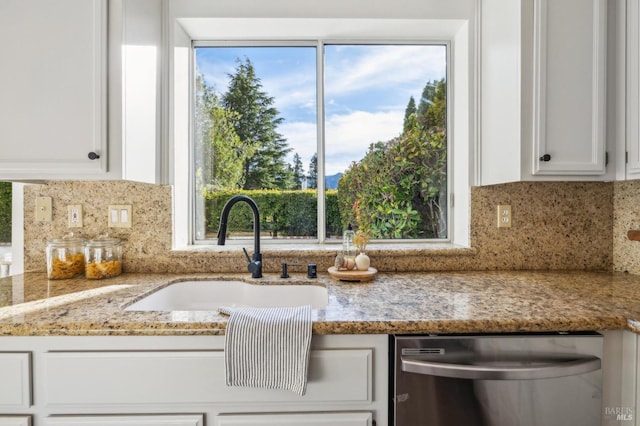 kitchen featuring white cabinetry, dishwasher, light stone countertops, sink, and decorative backsplash