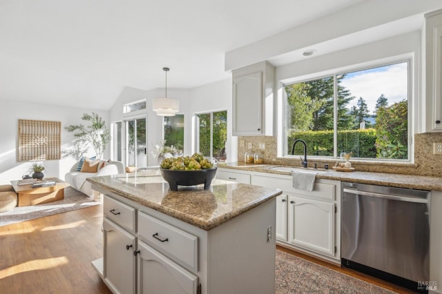 kitchen with sink, stainless steel dishwasher, backsplash, decorative light fixtures, and white cabinets