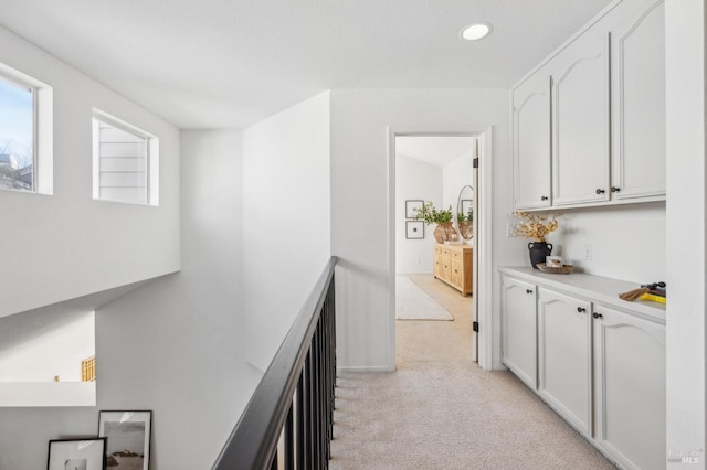 hallway with light colored carpet