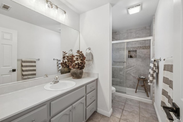 bathroom with toilet, vanity, tile patterned floors, and an enclosed shower