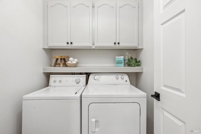 washroom with washing machine and dryer and cabinets