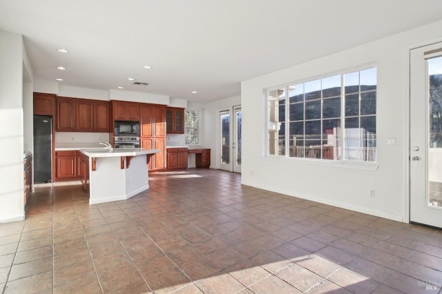 kitchen featuring a center island with sink, a kitchen breakfast bar, and stainless steel appliances