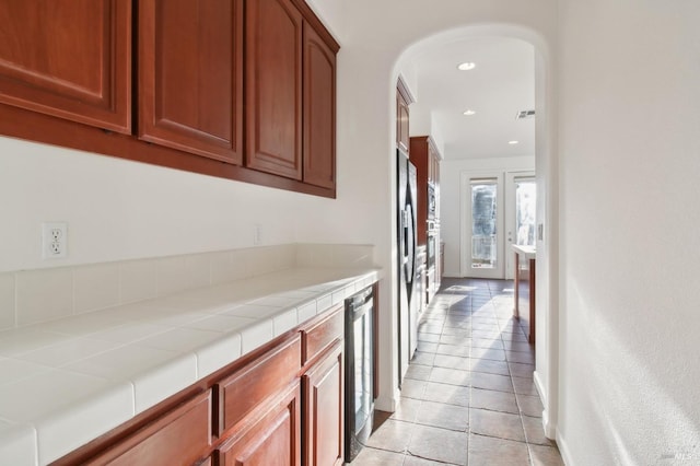 hallway with light tile patterned floors and beverage cooler