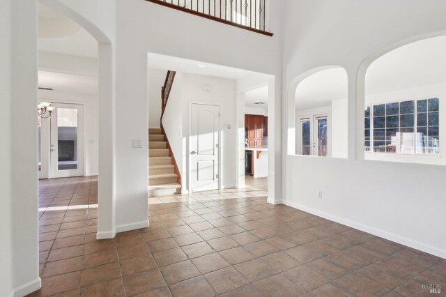 corridor with light tile patterned floors, arched walkways, wine cooler, visible vents, and recessed lighting